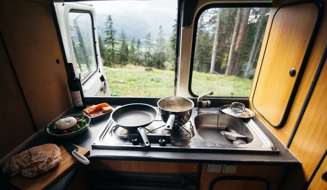 outdoor-spuele blick aus dem Camperfenster vom Herd in die freie Natur