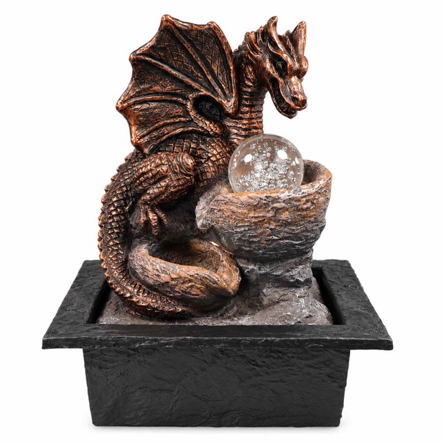 Zimmerbrunnen Drache mit rotierender Glaskugel und LED-Lichtern Kupferfarbener Drachen-Zimmerbrunnen mit ausgebreiteten Flügeln und geschupptem Körper, daneben eine Schale mit klarer Glaskugel auf einem schwarzen, strukturierten Sockel.